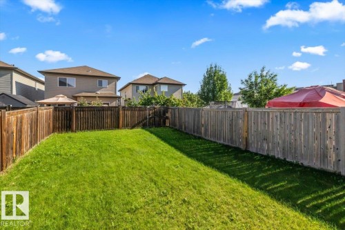 Expansive grassy yard area featuring full privacy fencing and a rear gate - 11506 17 Avenue Sw, Edmonton, AB 