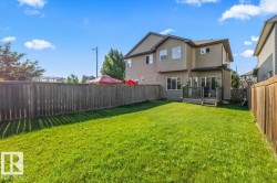 Expansive grassy yard with a wood fence perimeter - 