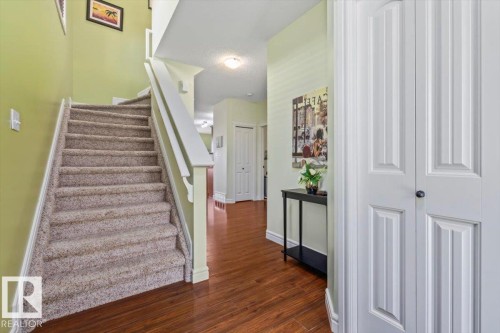 Staircase with carpeted treads and white wood-finish railing - 11506 17 Avenue Sw, Edmonton, AB 