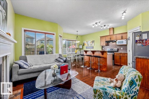 Hardwood-finish flooring throughout, complete kitchen with stainless steel appliances, breakfast bar, and tile backsplash - 11506 17 Avenue Sw, Edmonton, AB 