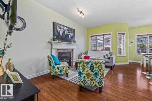 Built-in fireplace with a stone surround, wood mantel, and hearth - 11506 17 Avenue Sw, Edmonton, AB 