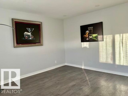 Smooth white walls with recessed ceiling lighting, wood-finish flooring, and white trim - 5614 50 Street, Vegreville, AB 