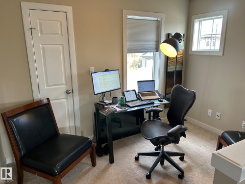 Neutral-toned walls, two distinct windows, and a panel door with a round doorknob - 20007 131 Avenue Nw, Edmonton, AB 