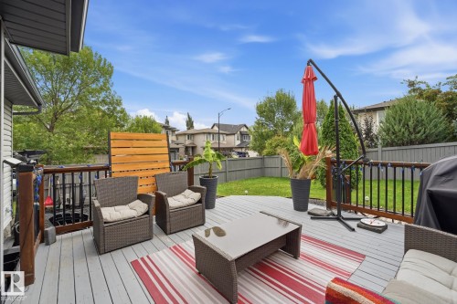 Spacious outdoor deck with a light-toned surface, dark railings, and a privacy screen - 20007 131 Avenue Nw, Edmonton, AB 