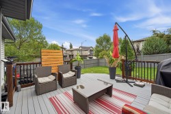 Spacious outdoor deck with a light-toned surface, dark railings, and a privacy screen - 