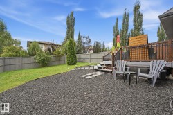Expansive backyard featuring a multi-level wooden deck, stone paver pathway, and a well-maintained lawn - 