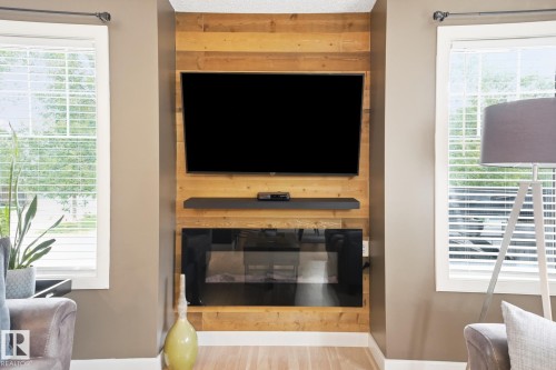 Reclaimed wood-finish accent wall with a built-in electric fireplace and a floating shelf - 20007 131 Avenue Nw, Edmonton, AB 