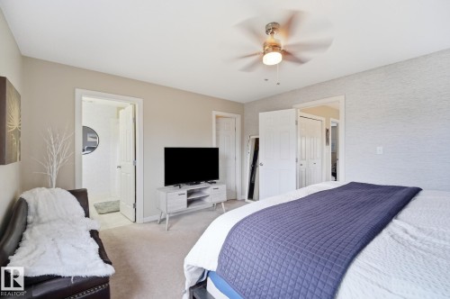 Neutral wall tones, carpeted flooring, textured accent wall, ceiling fan, and white trim throughout - 20007 131 Avenue Nw, Edmonton, AB 
