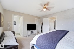 Neutral wall tones, carpeted flooring, textured accent wall, ceiling fan, and white trim throughout - 