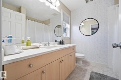 Single vanity with light wood-finish cabinetry and a light-toned countertop - 