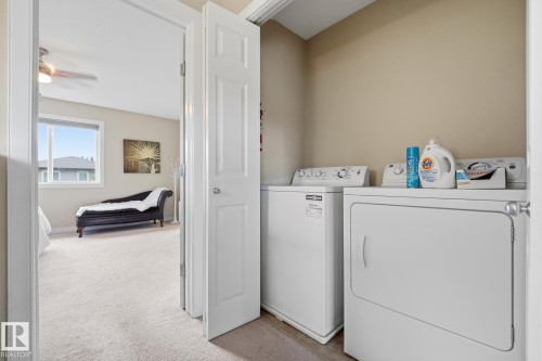 Dedicated laundry area with a white top-load washer and dryer - 20007 131 Avenue Nw, Edmonton, AB 