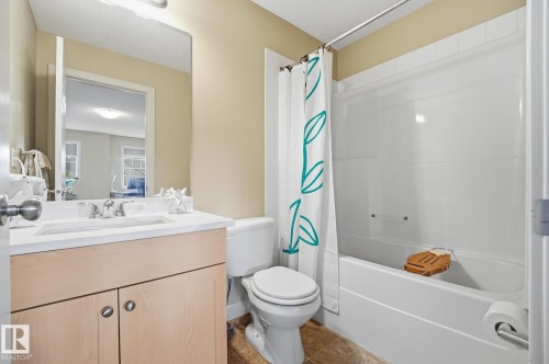 Vanity with integrated sink, wood-finish cabinetry, and brushed nickel hardware - 20007 131 Avenue Nw, Edmonton, AB 