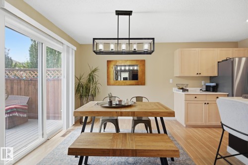 Sliding glass door, wood-finish flooring, recessed lighting, wood cabinetry, and a rectangular chandelier - 20007 131 Avenue Nw, Edmonton, AB 