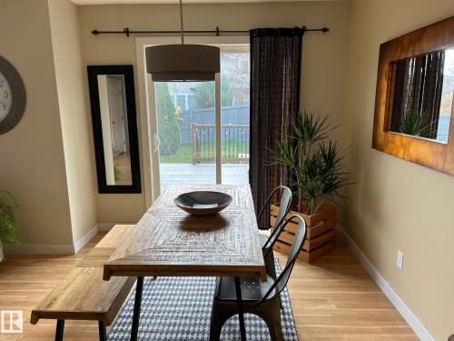 Sliding glass door, wood-finish flooring, drum pendant light fixture, and neutral wall tones - 20007 131 Avenue Nw, Edmonton, AB 
