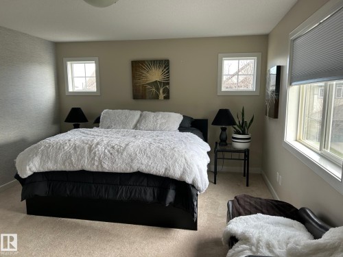 Soft neutral wall color, textured accent wall, two window openings, recessed ceiling lighting, and light-toned carpet flooring - 20007 131 Avenue Nw, Edmonton, AB 