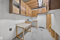Built-in cabinetry, concrete flooring, exposed ceiling joists, and a utility sink - 