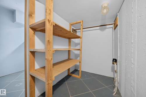 Built-in wood shelving and storage rod, tile flooring, and overhead lighting - 155 Marlborough Place Nw, Edmonton, AB 