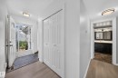Entry foyer featuring slate-style tile flooring, wood-finish flooring, and white bi-fold closet doors - 155 Marlborough Place Nw, Edmonton, AB 