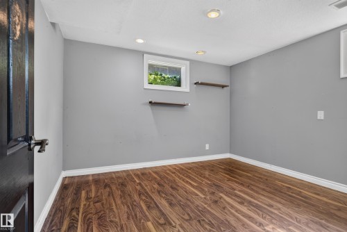 Wood-finish flooring, recessed ceiling lighting, light gray wall paint, and built-in wall shelving - 13351 109A Avenue Nw, Edmonton, AB 