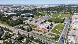 Expansive neighborhood featuring a large university campus, multiple athletic fields, tennis courts, and mature trees throughout - 