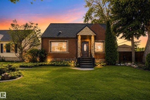 Brick exterior with stone accents, covered front entry, and mature landscaping - 13351 109A Avenue Nw, Edmonton, AB 