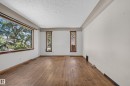 Wood-finish flooring with a large picture window and two vertical windows - 13351 109A Avenue Nw, Edmonton, AB 