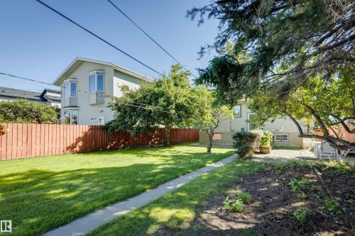 Expansive lawn with a concrete pathway leading to a paved patio - 10916 151 Street Nw, Edmonton, AB 