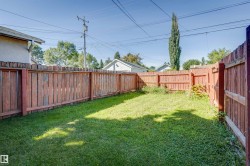 Enclosed backyard featuring wood privacy fencing and a grass lawn - 
