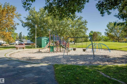 Recreational playground area featuring a multi-component play structure, swings, and a climbing arch - 10916 151 Street Nw, Edmonton, AB 