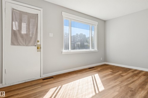 Wood-finish flooring, white trim, and a large window - 10916 151 Street Nw, Edmonton, AB 
