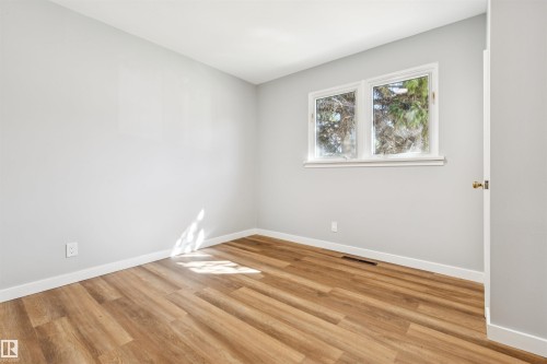 Wood-finish flooring, white trim, and light gray walls - 10916 151 Street Nw, Edmonton, AB 