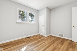 Two pane window, light gray wall finish, wood-finish flooring, white trim, and white doors - 