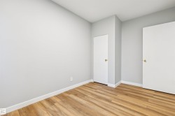 Wood-finish flooring, light grey walls, and white trim - 