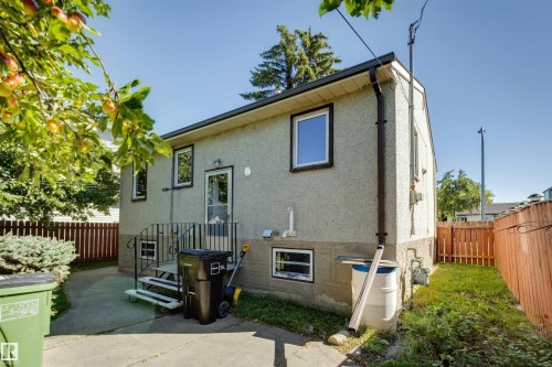 Stucco exterior featuring multiple windows and a rear entry - 10916 151 Street Nw, Edmonton, AB 