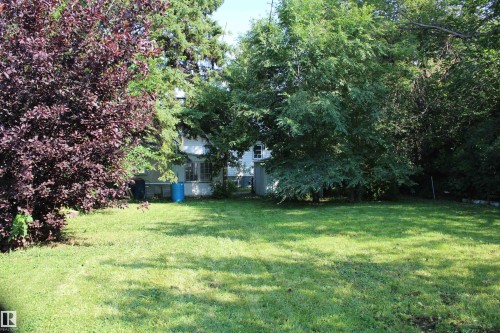 Expansive green lawn with mature trees and established perimeter landscaping - 4406 49A Street, Vegreville, AB 