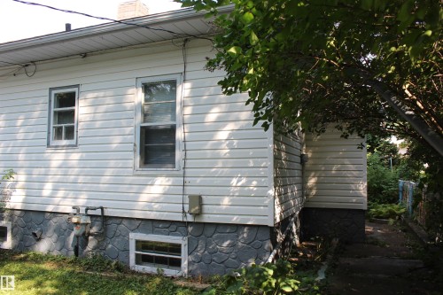 White horizontal siding exterior with a textured foundation - 4406 49A Street, Vegreville, AB 