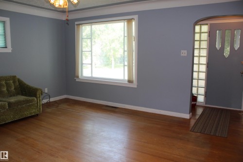 Hardwood flooring, bay window, arched entryway, glass block sidelight, ceiling-mounted light fixture - 4406 49A Street, Vegreville, AB 