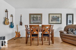 Dining area featuring wood-finish flooring, a wood dining table, and white painted walls - 