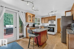 Kitchen with wood-finish flooring, wood cabinetry, and a central island with a countertop - 