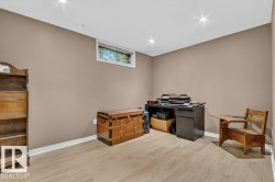 Spacious room featuring light wood-finish flooring, neutral wall paint, recessed ceiling lighting, a white window frame, and white baseboards - 