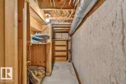 Unfinished basement area featuring exposed wood framing, concrete foundation walls, a concrete floor, and exposed ceiling utilities - 