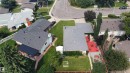 Property featuring a multi-level roofline, a covered patio with brick pavers, and a spacious green lawn - 11131 35A Avenue Nw, Edmonton, AB  - Outdoor With View 