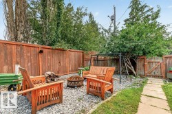 Gravel outdoor area featuring a fire pit, wood fencing, and a stepping stone pathway - 