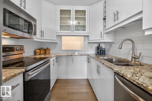 What if you have armloads of groceries?  No Problem. This cleverly designed galley kitchen with convenient pass-through has 2 pullout pantry cupboards and space galore for all your dishes and appliances. - #602 12303 Jasper Av Nw, Edmonton, AB 