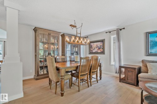 Light wood-finish flooring, recessed lighting, and a modern rectangular chandelier - 591 Byrne Crescent Sw, Edmonton, AB 