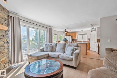 Stacked stone fireplace with a wood mantel - 591 Byrne Crescent Sw, Edmonton, AB 