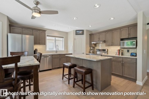 Kitchen featuring wood-finish flooring, recessed lighting, and a center island with counter seating - 591 Byrne Crescent Sw, Edmonton, AB 