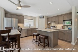 Kitchen featuring wood-finish flooring, recessed lighting, and a center island with counter seating - 