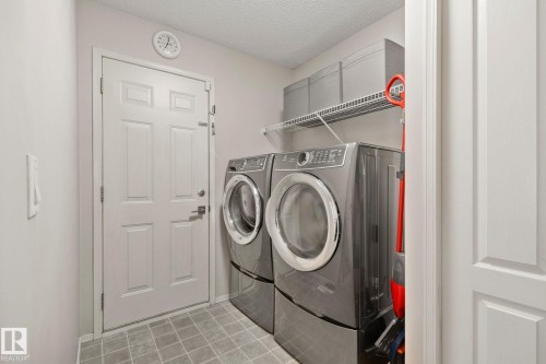 Utility space featuring tiled flooring and a wall-mounted storage shelf - 591 Byrne Crescent Sw, Edmonton, AB 