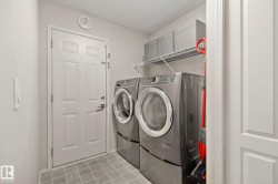 Utility space featuring tiled flooring and a wall-mounted storage shelf - 